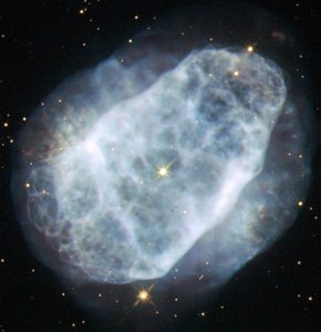 This NASA/ESA Hubble Space Telescope image shows a planetary nebula named NGC 6153, located about 4000 light-years away in the southern constellation of Scorpius (The Scorpion). The faint blue haze across the frame shows what remains of a star like the Sun after it has depleted most of its fuel. When this happens, the outer layers of the star are ejected, and get excited and ionised by the energetic ultraviolet light emitted by the bright hot core of the star, forming the nebula. NGC 6153 is a planetary nebula that is elliptical in shape, with an extremely rich network of loops and filaments, shown clearly in this Hubble image. However, this is not what makes this planetary nebula so interesting for astronomers. Measurements show that NGC 6153 contains large amounts of neon, argon, oxygen, carbon and chlorine — up to three times more than can be found in the Solar System. The nebula contains a whopping five times more nitrogen than the Sun! Although it may be that the star developed higher levels of these elements as it grew and evolved, it is more likely that the star originally formed from a cloud of material that already contained lots more of these elements. A version of this image was entered into the Hubble’s Hidden Treasures image processing competition by contestant Matej Novak. Links Matej Novak’s image on Flickr