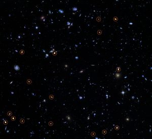 This image combines a background picture taken by the NASA/ESA Hubble Space Telescope (blue/green) with a new very deep ALMA view of this field (orange, marked with circles). All the objects that ALMA sees appear to be massive star-forming galaxies. This image is based on the ALMA survey by J. Dunlop and colleagues, covering the full HUDF area.