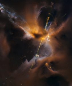 The two lightsabre-like streams crossing the image are jets of energised gas, ejected from the poles of a young star. If the jets collide with the surrounding gas and dust they can clear vast spaces, and create curved shock waves, seen as knotted clumps called Herbig-Haro objects.