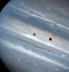 The three snapshots of the volcanic moon rounding Jupiter were taken over a 1.8-hour time span. Io is roughly the size of Earth's moon but 2,000 times farther away. In two of the images, Io appears to be skimming Jupiter's cloud tops, but it's actually 310, 000 miles (500,000 kilometers) away. Io zips around Jupiter in 1.8 days, whereas the moon circles Earth every 28 days. The conspicuous black spot on Jupiter is Io's shadow and is about the size of the moon itself (2,262 miles or 3,640 kilometers across). This shadow sails across the face of Jupiter at 38,000 mph (17 kilometers per second). The smallest details visible on Io and Jupiter measure 93 miles (150 kilometers) across, or about the size of Connecticut.